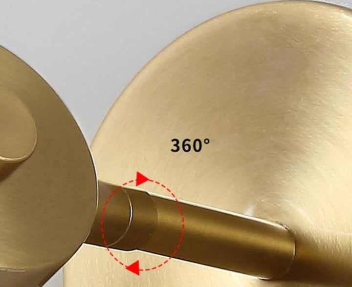 Lámpara de pared de diseño interior, acabada en latón dorado. Luz ajustable para ambientes modernos.