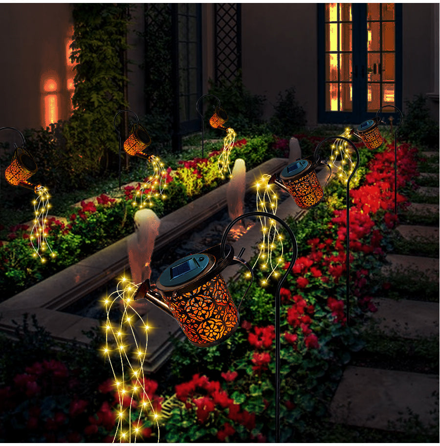 Regadera lámpara solar iluminando el jardín de noche, luz LED decorativa, ambiente mágico para patio exterior.