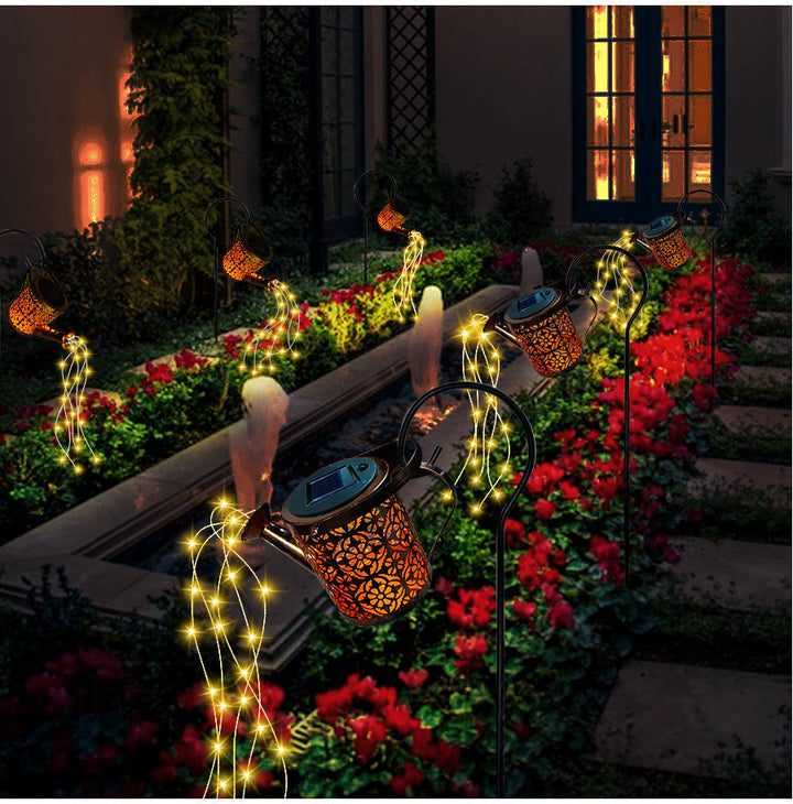 Regadera lámpara solar iluminando el jardín de noche, luz LED decorativa, ambiente mágico para patio exterior.