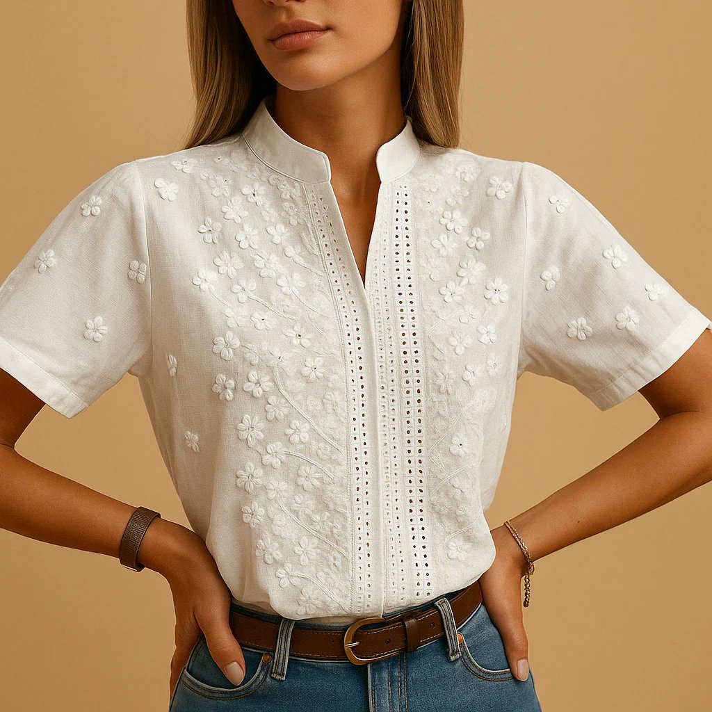 Blusa blanca de mujer con exquisitos bordados florales, mangas abullonadas y diseño versátil.