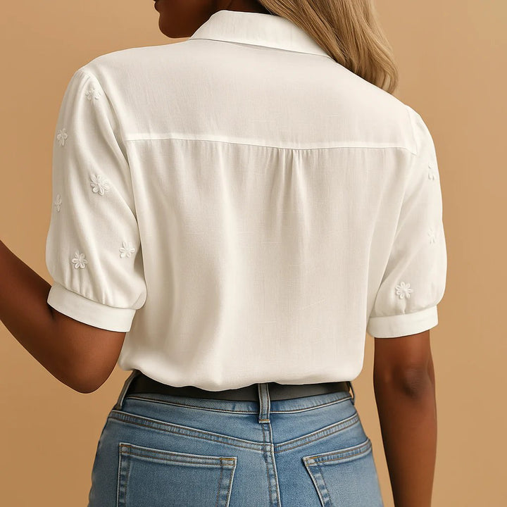 Blusa elegante para mujer en blanco, con bordado floral detallado y mangas abullonadas, moda primavera.