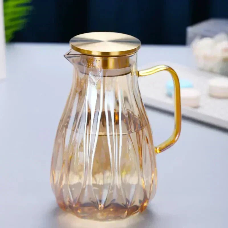 Jarra de vidrio elegante para bebidas frías, con asa y tapa de acero inoxidable, ideal para cocina y mesa.