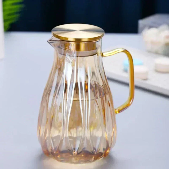 Jarra de vidrio elegante para bebidas frías, con asa y tapa de acero inoxidable, ideal para cocina y mesa.