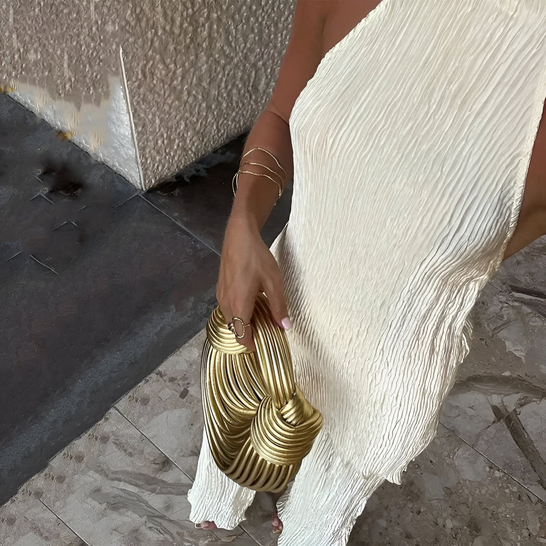 Mono plisado beige de mujer, diseño elegante con cuello halter y pierna ancha. Ropa de fiesta y ocasión especial.