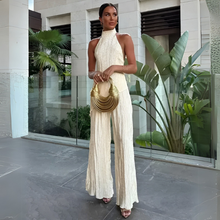 Mono elegante beige para mujer con cuello halter y pierna ancha plisada. Ideal para fiestas y ocasiones especiales.