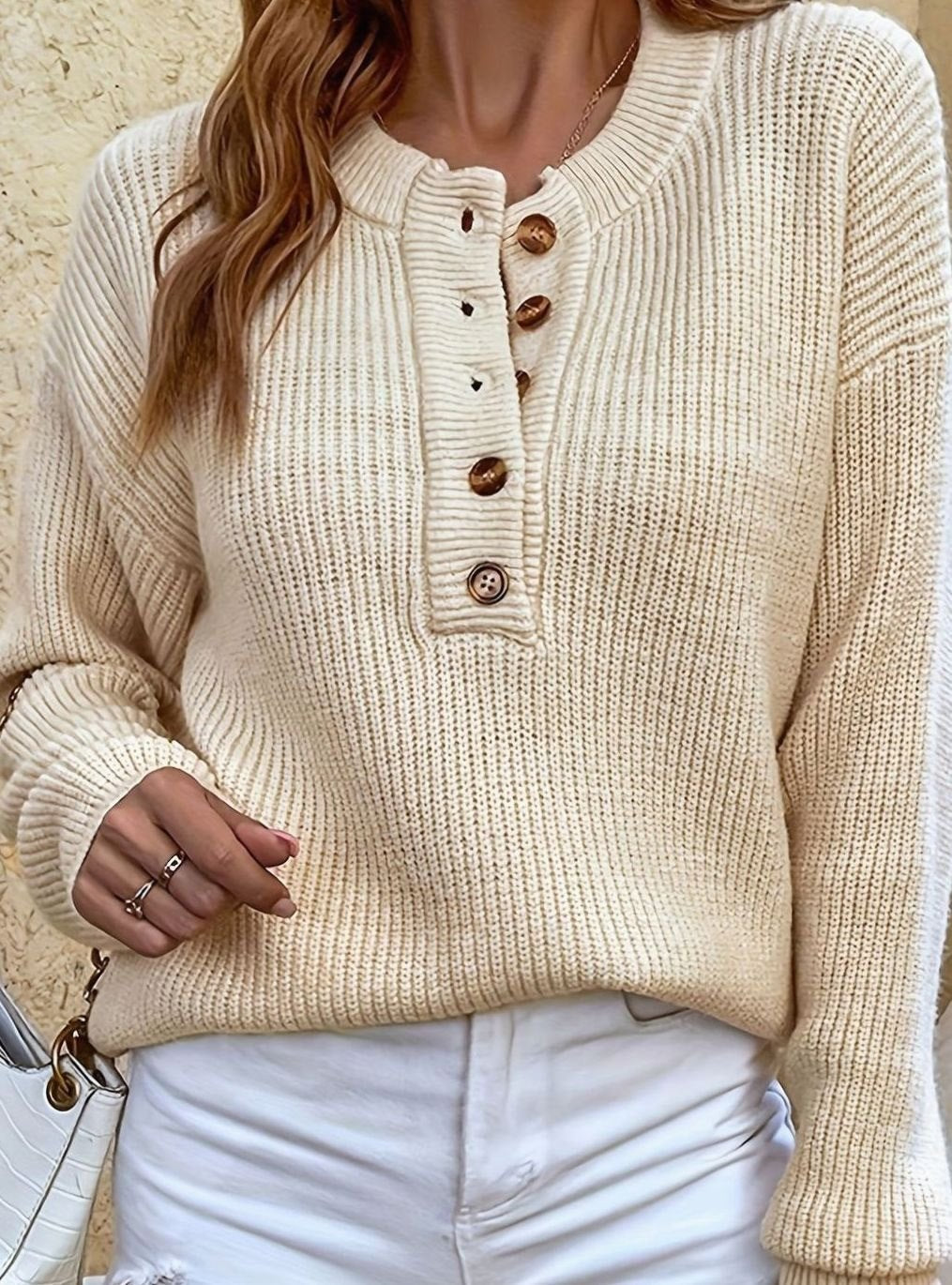 Detalle de tejido canalé en jersey de mujer, con clásico cuello Henley y tres botones.