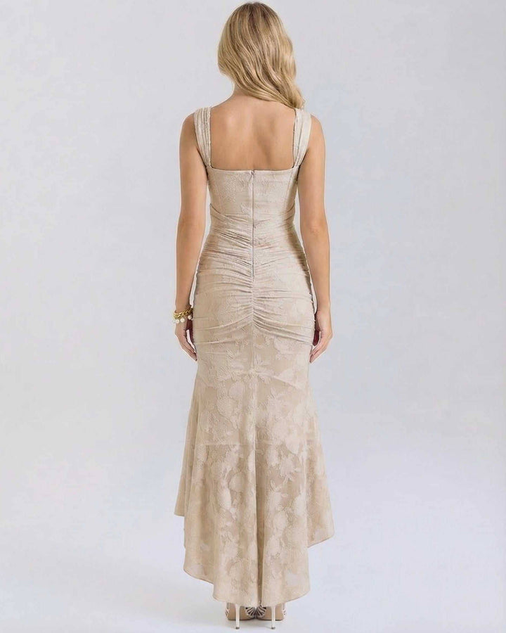 Vestido de noche formal maxi color nude con cola de pez y detalle floral, sin mangas para ocasiones especiales.