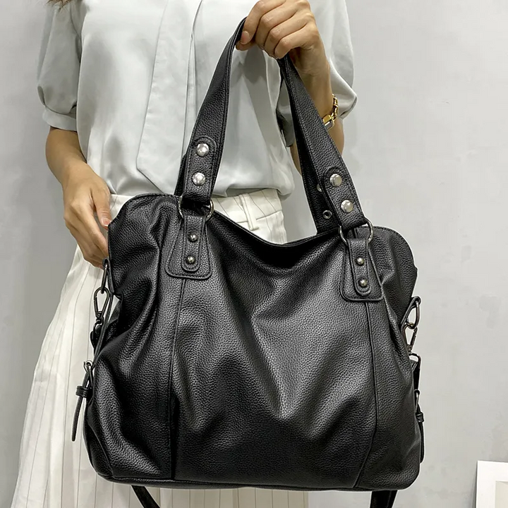 Bolso de hombro negro, grande, de cuero vegano suave. Con múltiples compartimentos organizadores.