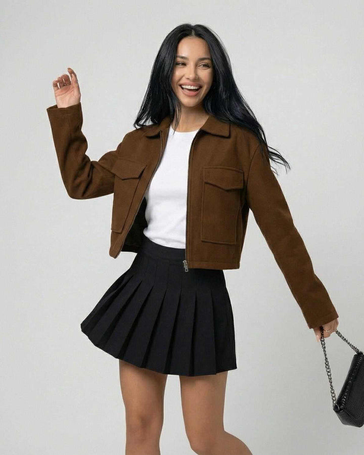 Modelo luciendo chaqueta Sahara marrón de mujer. Estilo urbano, cuello polo y cremallera. Perfecta para otoño.