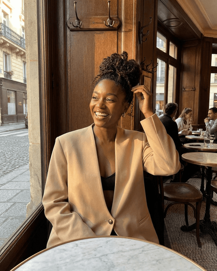 Mujer vistiendo blazer entallado beige, combinado con ropa de oficina, elegante y sofisticado.