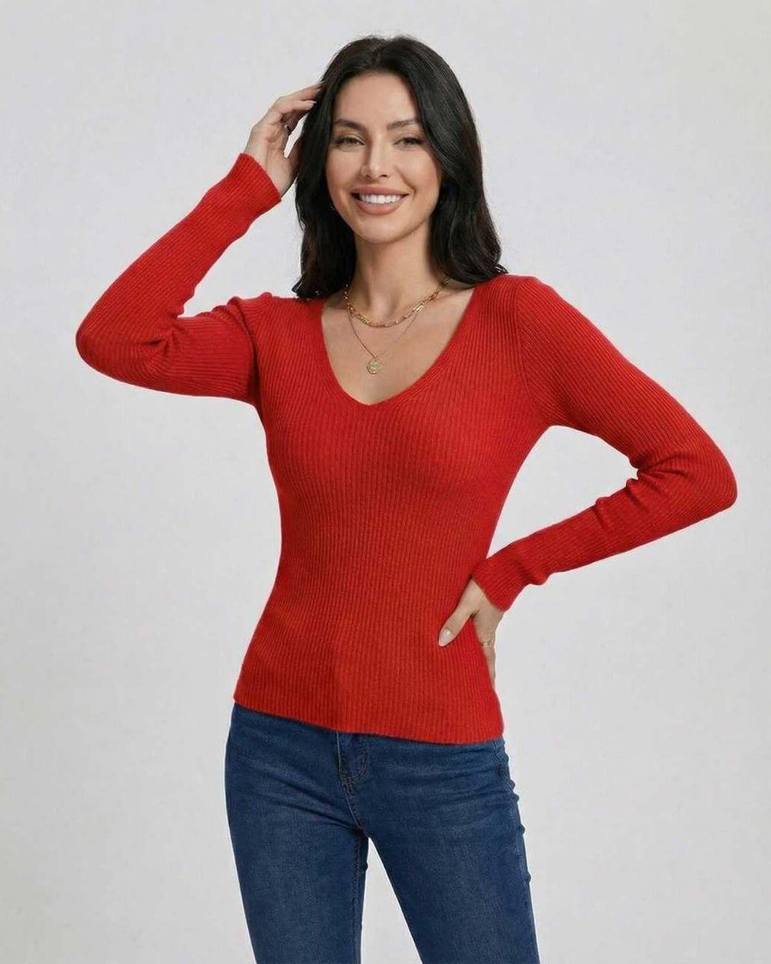Detalle de suéter rojo escarlata de mujer con cuello en V, tejido suave, manga larga.
