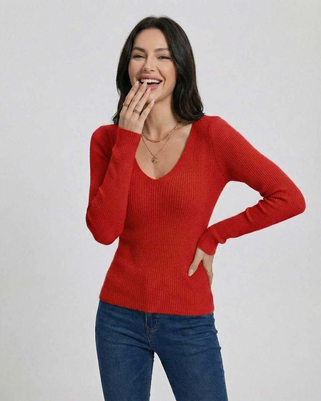 Mujer luciendo suéter cuello V escarlata de ajuste elegante. Tendencia de moda para otoño.
