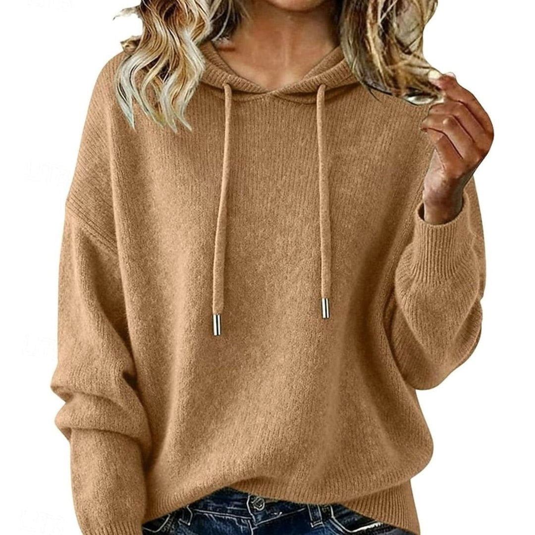 Mujer modelando sudadera con capucha y cordón, corte relajado. Ropa cómoda de otoño para un estilo casual.