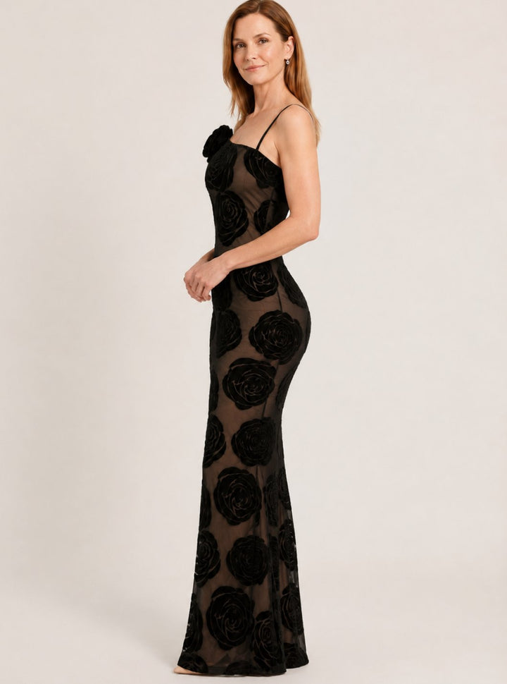 Elegante vestido de fiesta negro maxi con encaje floral y estilo un hombro, ideal para ocasiones especiales.
