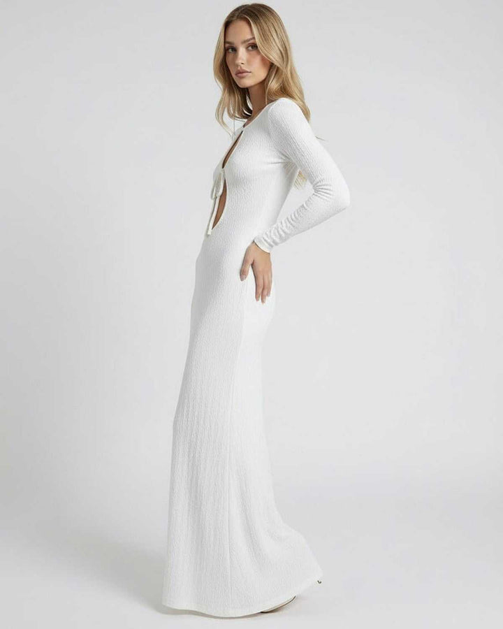 Vestido maxi blanco con detalles de corte hueco, mangas largas y escote redondo; moda versátil para mujer.