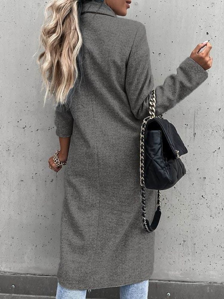 Mujer modelando abrigo largo de invierno, estilo elegante y sofisticado para días fríos.