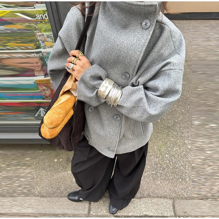 Mujer caminando con abrigo de cuello alto. Estilo clásico y confort para el otoño-invierno.