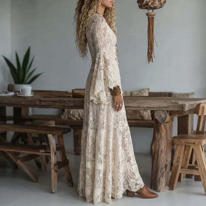 Mujer luce un vestido largo de encaje vintage con delicadas mangas acampanadas. Estilo romántico y elegante.