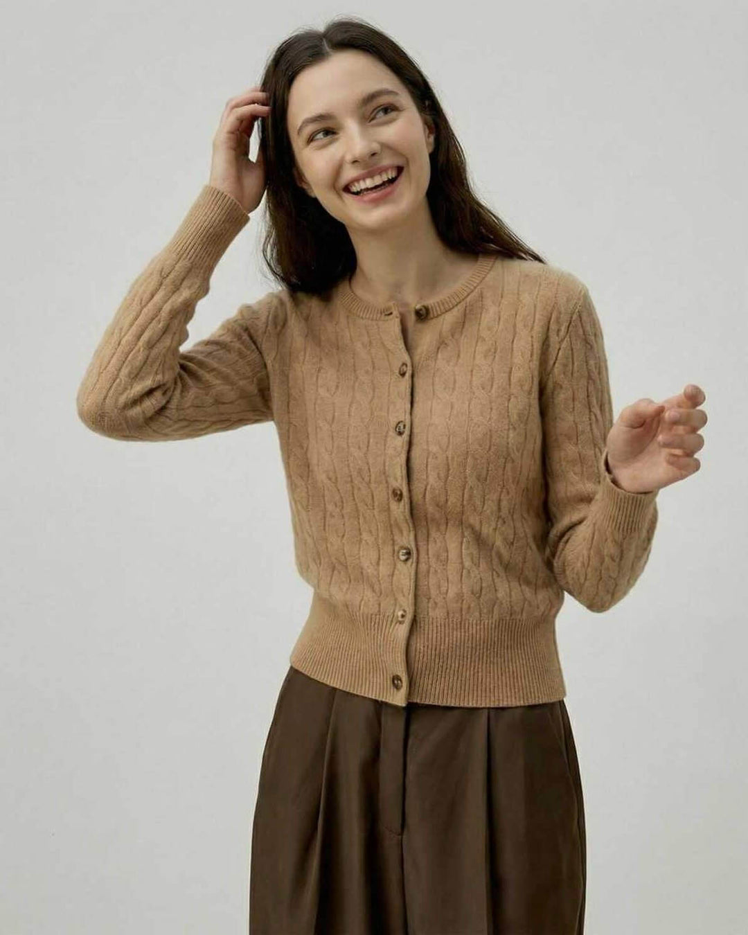 Primer plano del tejido trenzado del cárdigan Sienna marrón para mujer. Suéter de alta calidad para otoño/invierno.