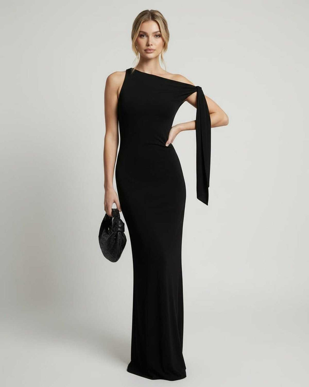Mujer luciendo un elegante vestido maxi negro de un hombro, perfecto para una fiesta, boda o evento formal moderno.