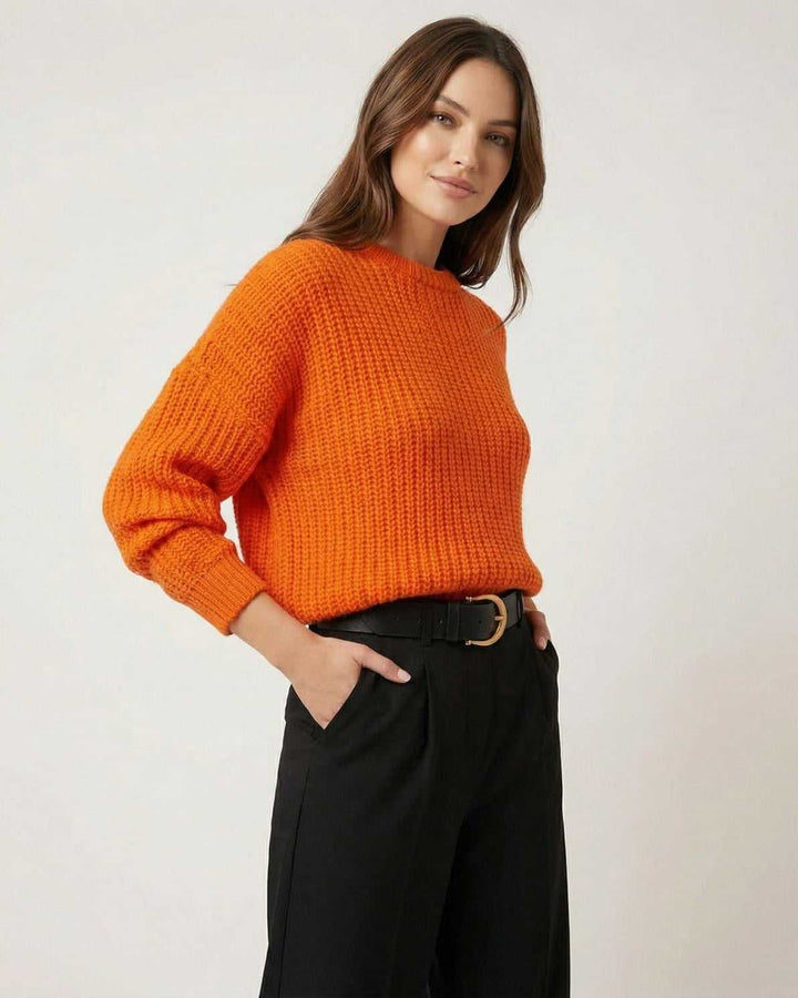Mujer con suéter blanco de punto, look casual y relajado. Comodidad y tendencia de moda.