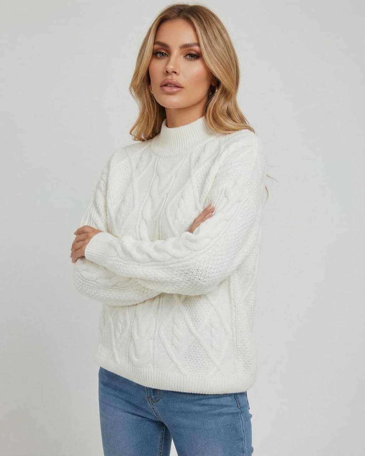 Mujer vistiendo suéter blanco oversized de manga larga y cuello redondo. Look casual y acogedor para otoño/invierno.