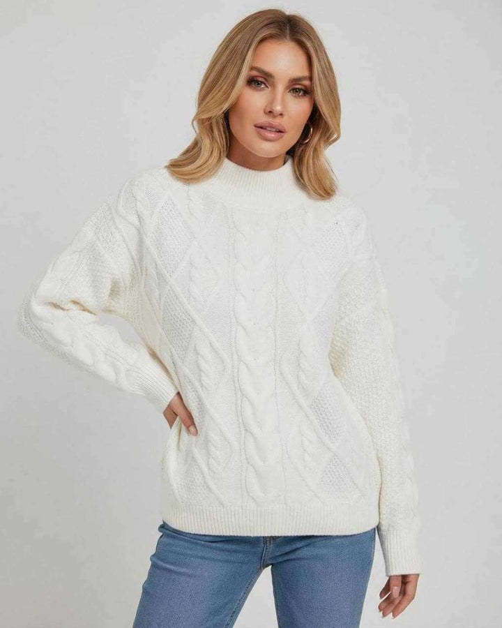 Detalle de suéter blanco oversized para mujer. Textura suave de punto, manga larga y cuello redondo, perfecto para invierno.