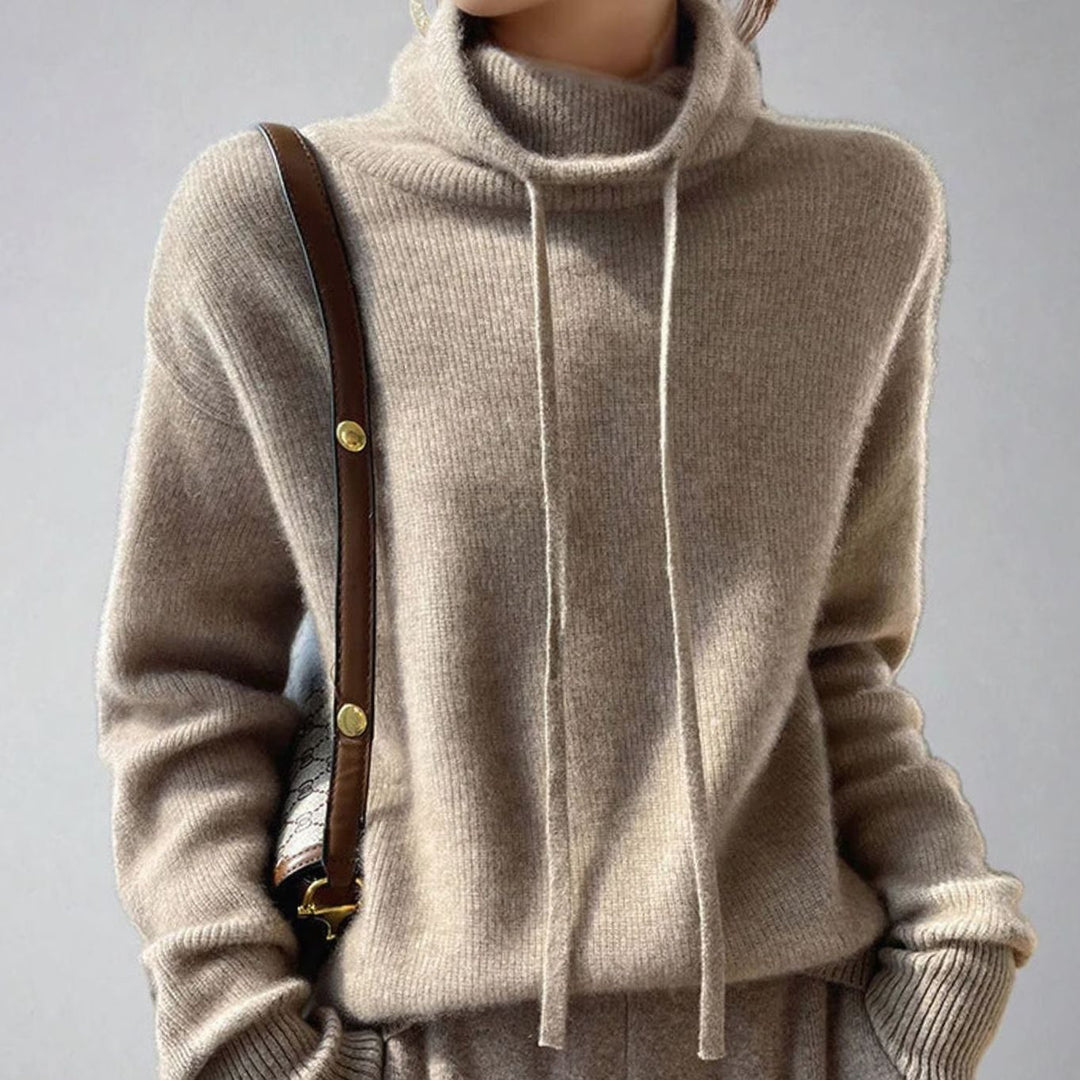 Jersey rosapastel de punto holgado con cuello alto y cordón para mujer, estilo moderno y casual.