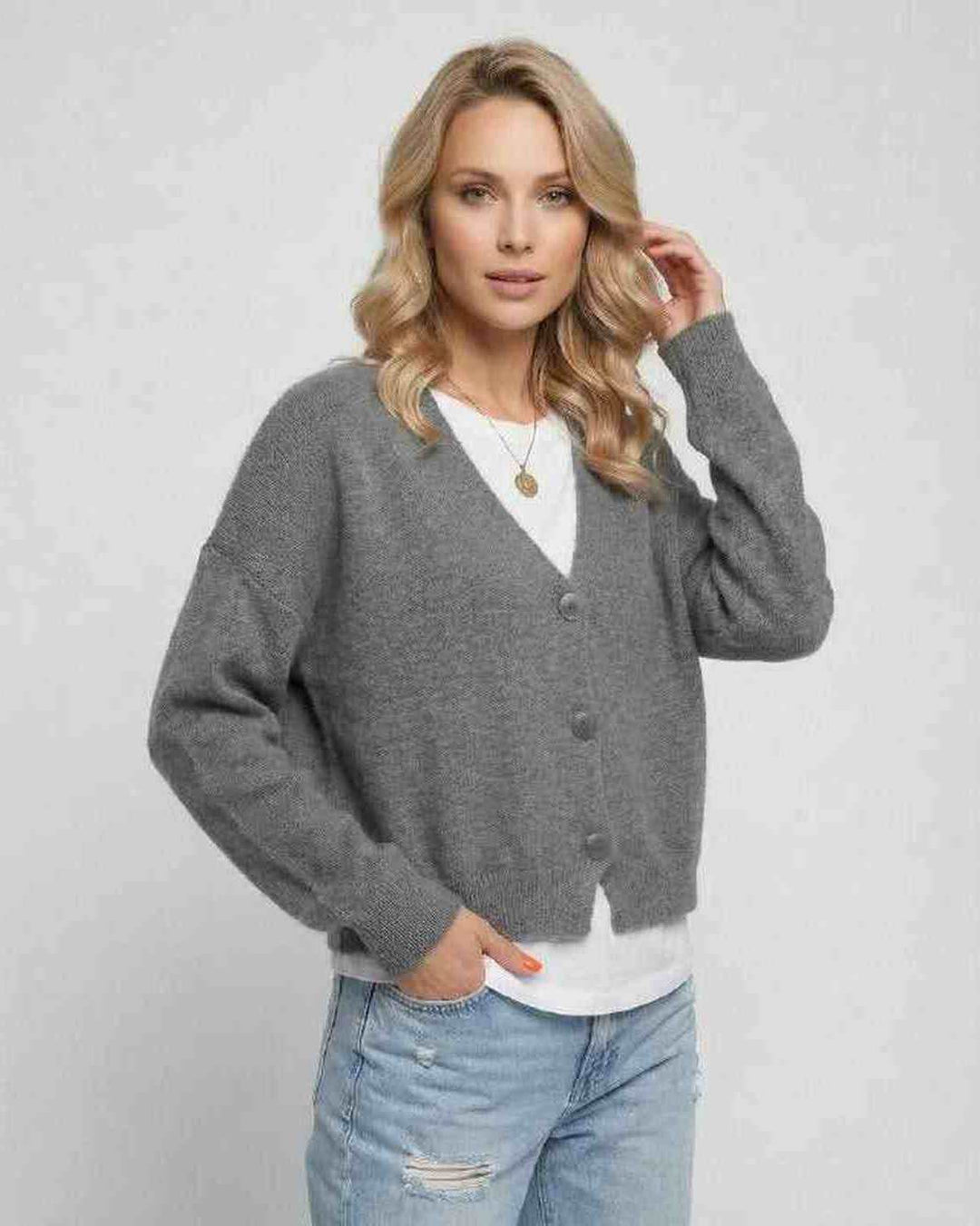 Detalle de textura de cárdigan gris de mujer, tejido suave y diseño clásico para moda femenina.