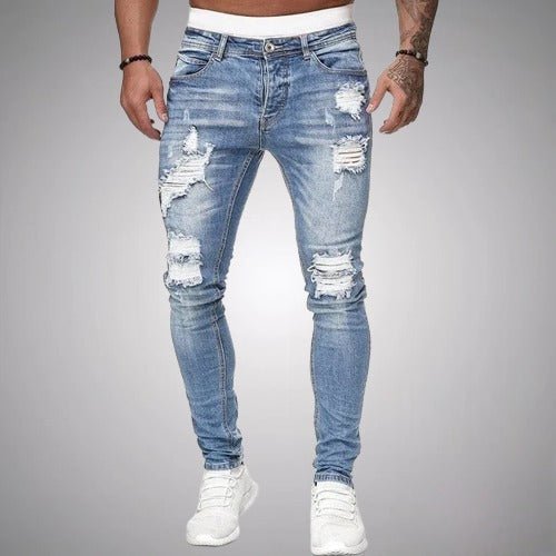 Vaqueros ajustados para hombre, color azul medio con zonas desgastadas. Moda masculina casual y moderna.