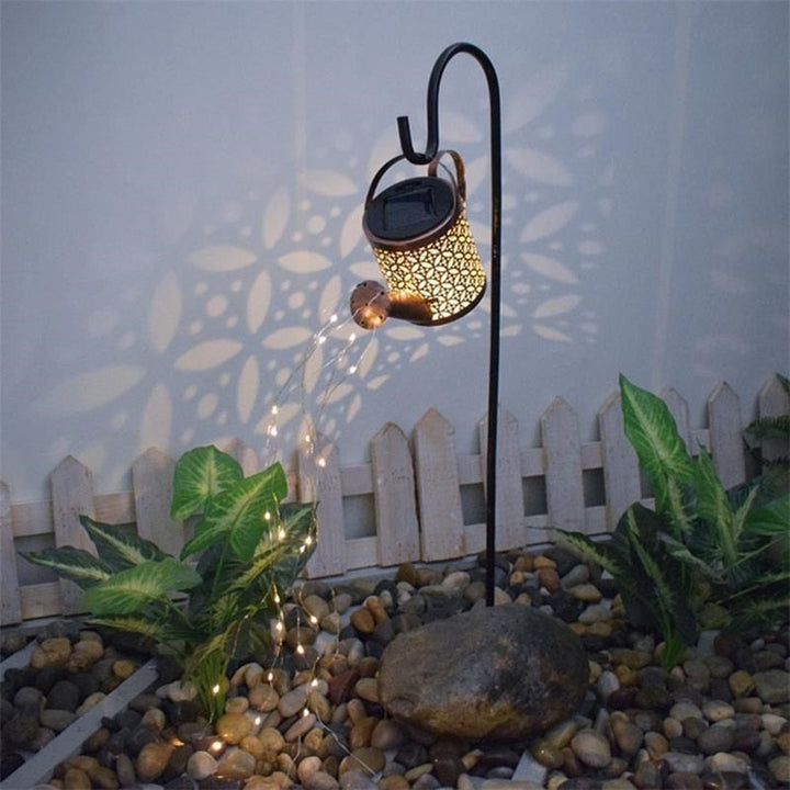 Regadera solar con luces LED cálidas, perfecta para realzar la decoración de tu jardín exterior.