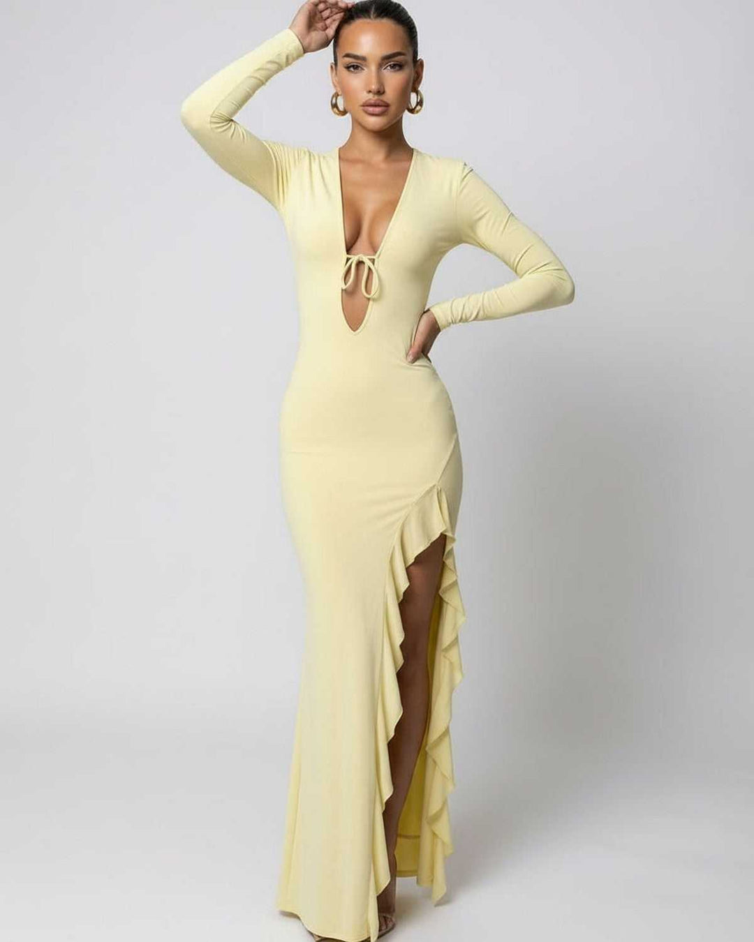 Primer plano del escote V y volantes en vestido maxi amarillo de mujer. Moda femenina.