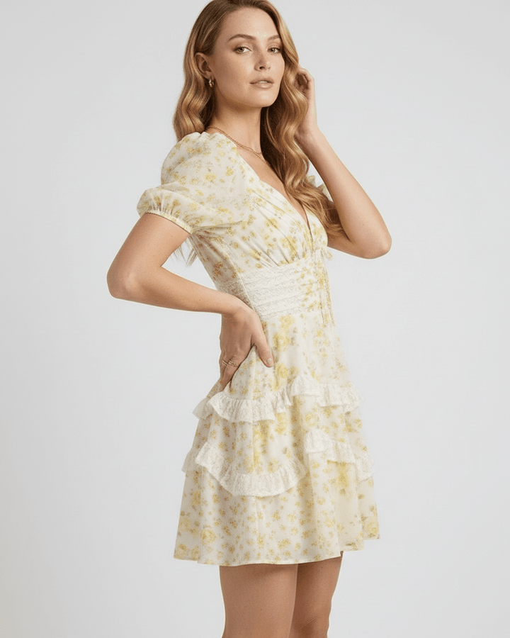 Vestido mini blanco con estampado floral, escote V profundo y volantes decorativos. Prenda versátil para verano.