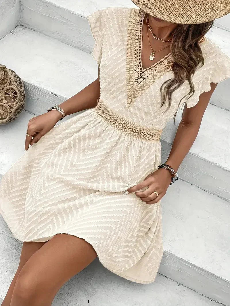 Moda femenina: vestido corto bordado con escote V y cintura entallada. Atuendo elegante y fresco.