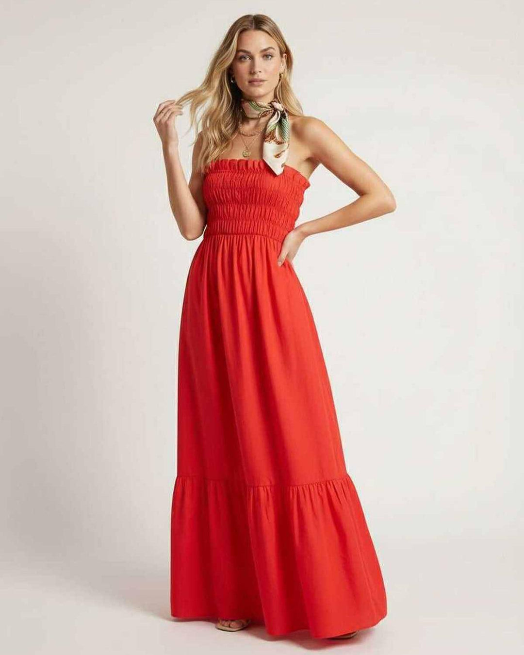 Mujer modelando vestido maxi blanco fruncido sin tirantes, perfecto para vacaciones.