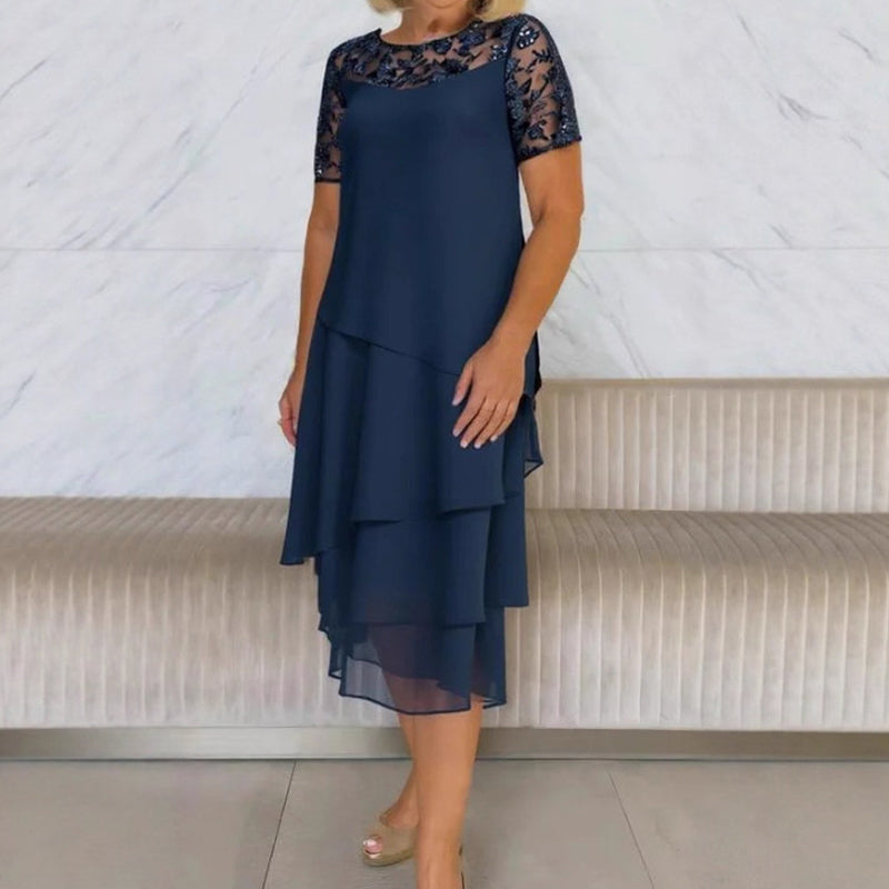 Mujer sonriendo con vestido midi de encaje blanco, perfecto para una fiesta elegante o evento de noche.