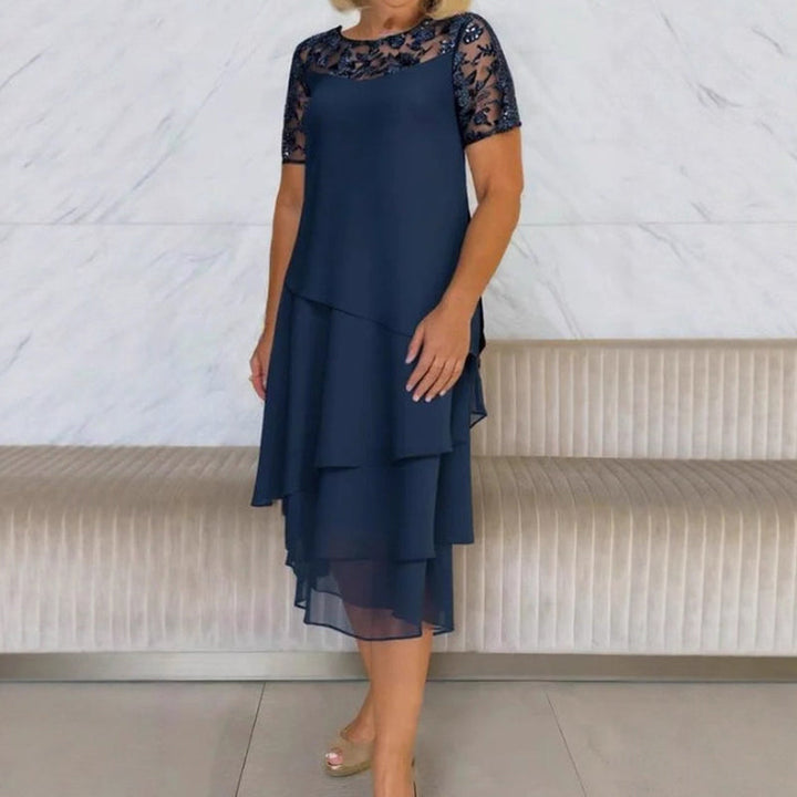 Mujer sonriendo con vestido midi de encaje blanco, perfecto para una fiesta elegante o evento de noche.