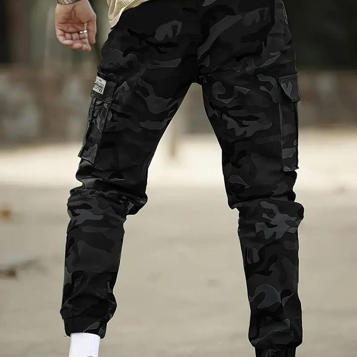 Hombre con pantalones de camuflaje, look urbano y casual, ideal para el día a día o la aventura.