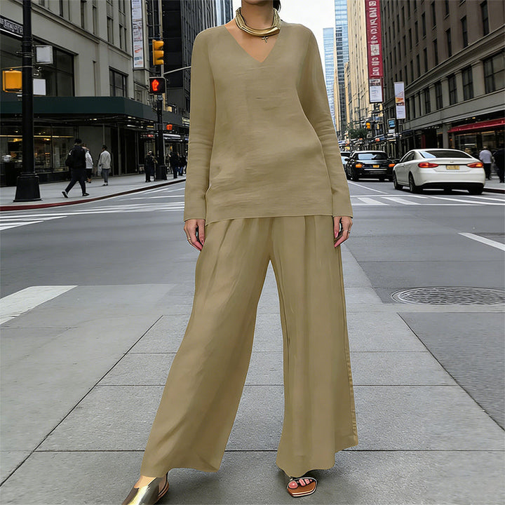 Mujer posando con conjunto cómodo de blusa escote V y pantalón ancho.
