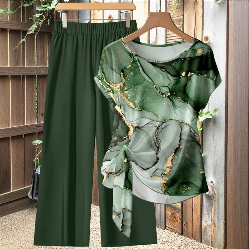 Outfit de verano elegante: conjunto de mujer con top estampado tropical vibrante y pantalón fluido blanco para un look fresco.