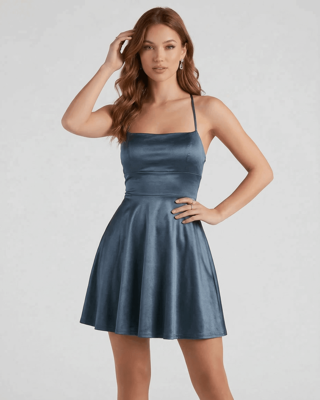 Mujer luciendo un elegante vestido mini azul acero, ideal para fiesta de verano.