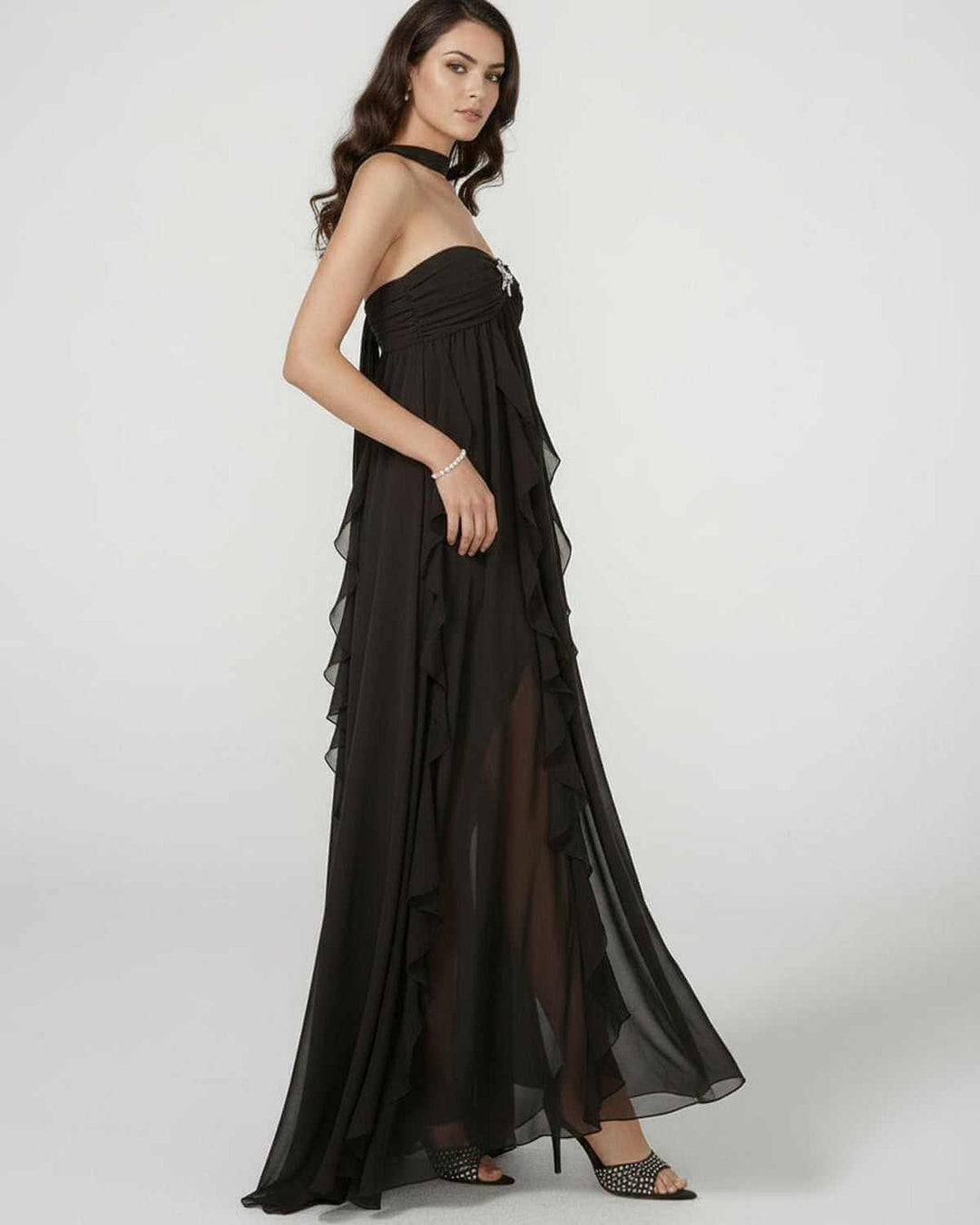 Mujer elegante en vestido maxi blanco sin tirantes, con borlas. Un look chic perfecto para fiestas, bodas o eventos nocturnos.