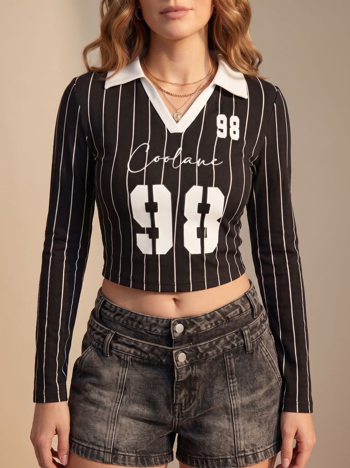 Top corto blanco con rayas negras, cuello polo, manga larga, estilo urbano, moda casual.