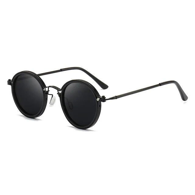 Elegantes gafas de sol unisex de montura redonda negra con detalles dorados. Protección UV. Accesorio de moda esencial.