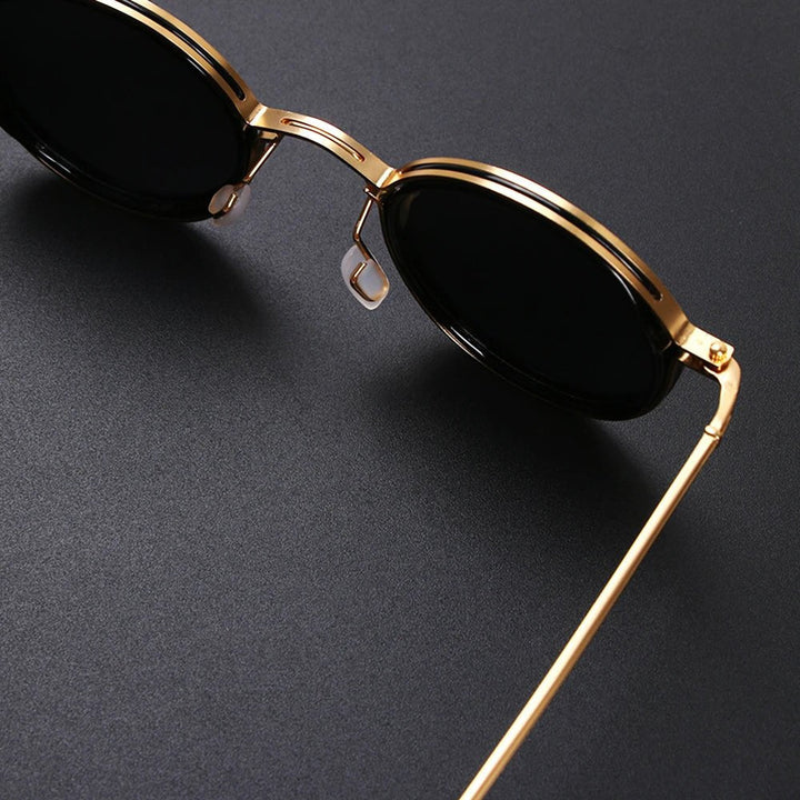 Gafas de sol con lentes polarizadas para anti-deslumbramiento y UV400. Montura redonda negra, varillas doradas. Visión clara.