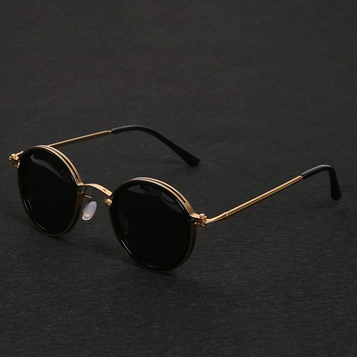 Gafas de sol polarizadas negras con montura redonda y varillas doradas. Estilo unisex y protección UV400. Verano.
