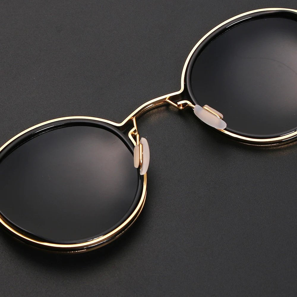 Accesorio de moda unisex: gafas de sol negras de montura redonda. Lentes polarizadas y varillas doradas. Protección UV.