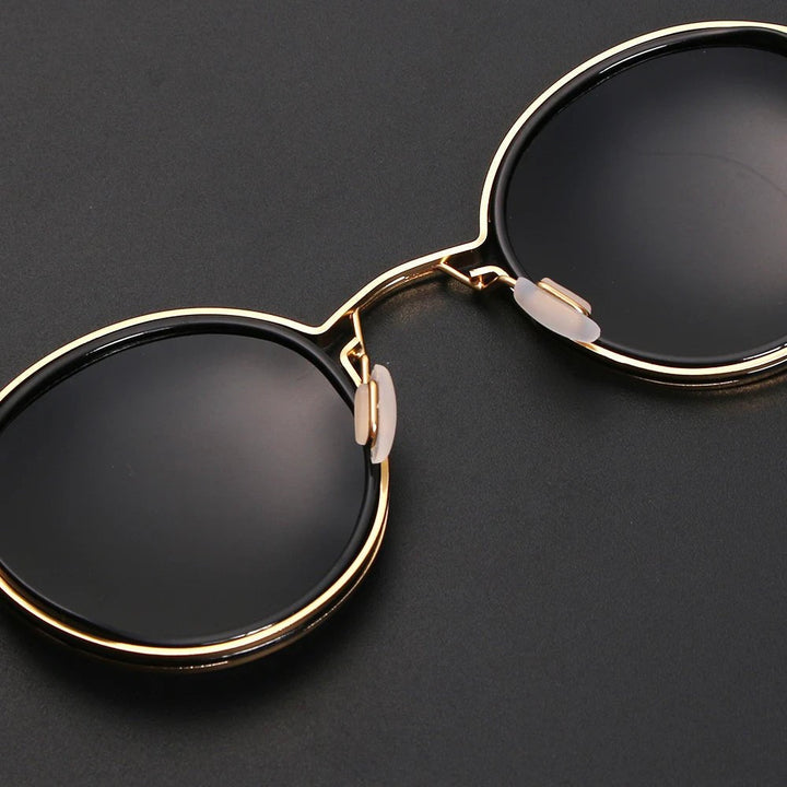 Accesorio de moda unisex: gafas de sol negras de montura redonda. Lentes polarizadas y varillas doradas. Protección UV.