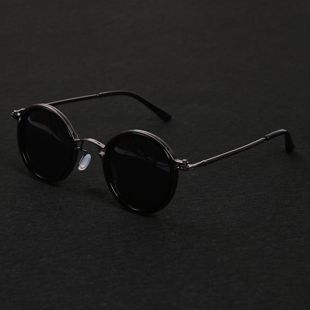 Gafas de sol polarizadas para exterior. Montura redonda negra, varillas doradas. Protección UV400, visión clara y confort.