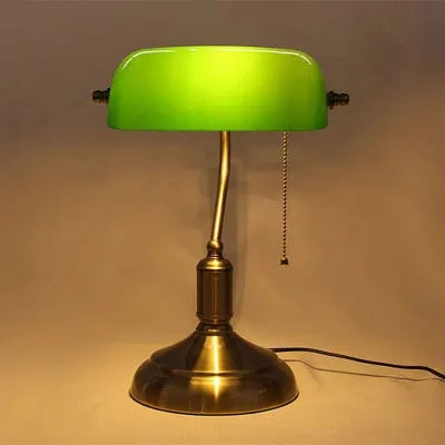 Lámpara de escritorio clásica de bronce. Proporciona luz cálida y ambiente vintage.